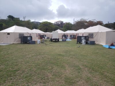 several tents in a field with equipment at each tent