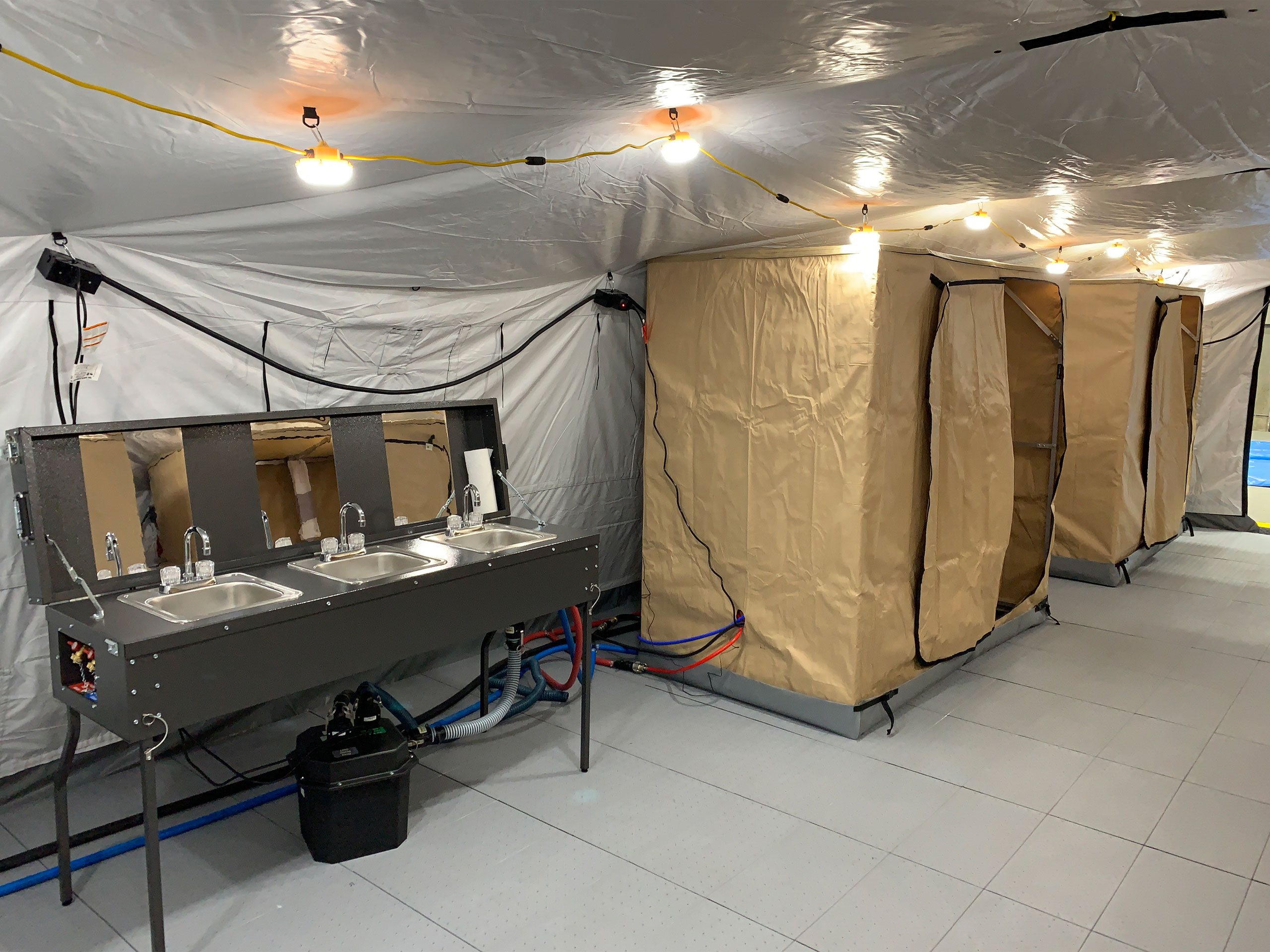 shower stalls next to sinks in a tent